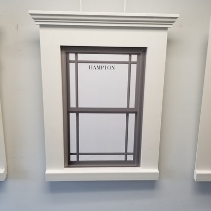 Window with decorative frame and 'Hampton' branding on a light gray wall.